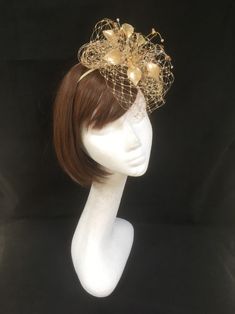 Delicate gold fascinator perfect for the guest who wants something fairly understated. This design is a beautiful selection of glass effect leaves and flowers with an additional scatter of brown crystal and tan glacier stone, clustered together amongst a fine layer of veiling and set onto a fine comfort base tiara band. As with all our designs, this piece can be made exact to the image or in any colour combination to match in with your outfit. If a specific colour is required customers can messa Gold Round Crown Headpiece For Weddings, Gold Wedding Headpiece With Round Crown, Gold Adjustable Headpiece With Structured Crown, Gold Crown Costume Headpiece For Weddings, Adjustable Crown-shaped Fascinator For Party, Royal Ascot Headband Fascinator For Event, Royal Ascot Headband Fascinator, Royal Ascot Event Headband Fascinator, Royal Ascot Structured Crown Headpiece