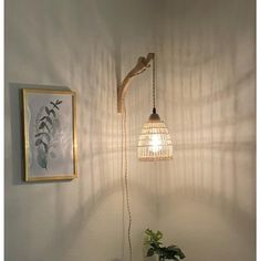 a lamp that is next to a potted plant on a table in front of a wall