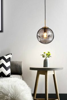 a living room with a couch, table and lamp on the wall next to it