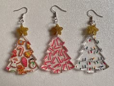 three christmas tree shaped earrings on a table