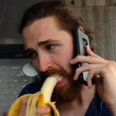 a man eating a banana while talking on a cell phone and holding a banana in his mouth