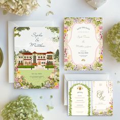 the wedding stationery is laid out with flowers and greenery