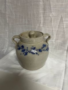 a blue and white vase sitting on top of a cloth covered tableclothed surface