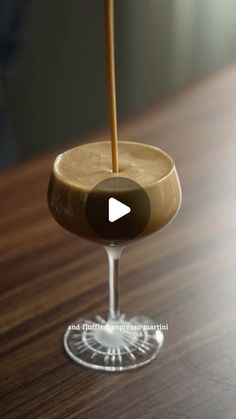 a drink in a glass on a table with a wooden stick sticking out of it