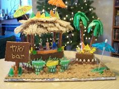 a table topped with a fake tiki bar and palm trees on top of it