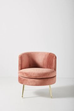 a pink chair sitting on top of a white floor