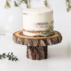 a white cake sitting on top of a wooden stand