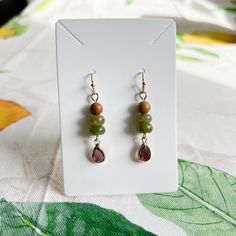 Gold Dangle Earrings Feature Wood Beads, Wine Ruby Garnet Red Crystal Glass Teardrops, Forest Moss Colored Deep Green Jade Beads And French Ball Ear Hooks. Also Available As A Set Approximately 2 Inch Drop Earrings Come With Silicone Stoppers Ships Within 2 Business Days Customization Available Made To Order Made With Love And Care Wine Ruby Garnet Red Crystal Forest Moss Green Jade Wood Bead Casual Earrings / Boho, Western, Dainty, Every Day, Daily Wear, Nature Earrings, Natural Stone, Beads, A Large Beaded Earrings, Natural Stone Earrings Handmade, Beaded Christmas Earrings, Cottage Core Earrings, Crystal Forest, Forest Moss, Bead Drop Earrings, Beaded Things, Bead Dangle Earrings