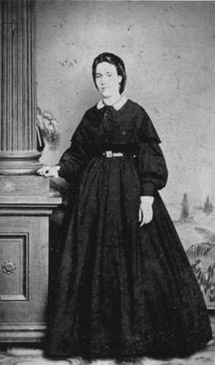 an old black and white photo of a woman in a long dress