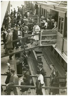 an old black and white photo of people boarding a train