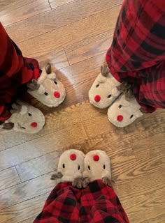 three people wearing slippers with red noses and nose shapes on their feet, standing in the middle of a wood floor