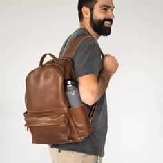 A classic backpack style with modern updates, including a premium luggage strap for convenient travel, an outside access phone pocket, fully adjustable straps, and a foam-lined laptop pocket. Whether on the work commute or heading to your next class or travel affair, this bag will effortlessly get you from point A to point B. There are two compartments with plenty of inside pockets to organize your life. Made with full-grain, luxury leather, this bag will be a staple for years to come. Every pur Leather Backpack For Trip, Business Backpack With Waxed Finish, Leather Backed Backpack For Everyday Use, Classic Backpack With Waxed Finish For Everyday Use, Modern Leather Backpack For Trip, Everyday Carry Soft Leather Backpack, Classic Waxed Backpack For Everyday, Classic Waxed Finish Backpack For Everyday, Soft Leather Everyday Backpack