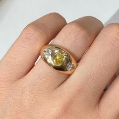 a woman's hand with a yellow and white diamond ring