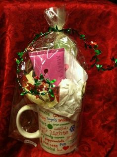 a coffee mug filled with lots of goodies on top of a red table cloth