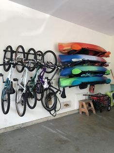 there are many surfboards and bicycles hanging on the wall