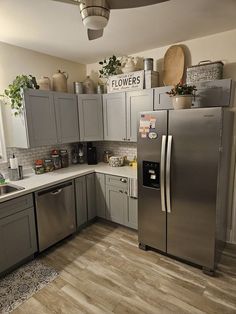 a kitchen with gray cabinets and stainless steel appliances