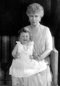 an old black and white photo of a woman holding a small child in her lap