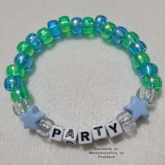 Holographic Blue And Holographic Green Yellow Pony Bead Bracelet "Party" With Clear Glittery And Solid Blue Star Bead Accents Double Stranded Elastic Kandi Bracelet Perfect For Emo, Scene, Y2k, Rave, Festival, Goth, Pastel Goth, Egirl, Gamer, Lgbt Pride Aesthetics. Elastic Bracelet Has Fair Stretch. Model Wrist 6.5" Model Hand 7.5" Please Check Measurements For Both. Please Do Not Exceed 8" Width, Elastic Will Break More Sizes Will Be Included Soon. Stock And Supplies Are Limited. Original Handm Party Jewelry With Tiny Blue Beads, Blue Tiny Beads For Party, Trendy Blue Beaded Bracelets For Party, Blue Beaded Bracelets For Party, Trendy Beaded Bracelets With Tiny Beads For Parties, Blue Beaded Bracelets With Spacer Beads For Party, Trendy Turquoise Bracelets For Party, Trendy Handmade Beads For Party, Trendy Handmade Party Beads