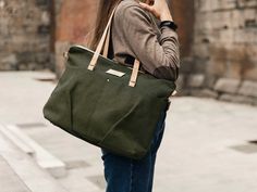 This personalised canvas shoulder bag for woman is both functional and stylish with a nice green khaki color. Pack it for a quick overnight trip, use it as an airplane carry on luggage, for your laptop, or even off to college in style! This large capacity canvas tote Bag also is the perfect size to use as a shopper bag for new moms! It is made with recycled canvas. The custom laptop bag has a zip top closure, and two external pockets. The Straps are portuguese cork in natural color and all hardw Recycled Handbag, Airplane Carry On, Convertible Tote Bag, Black Rucksack, Zippered Tote Bag, Vegan Tote Bag, Tote Bag With Pockets, Tote Bags For School, Bag With Pockets