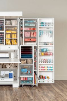 an organized sewing room with lots of crafting supplies on shelves and drawers in it