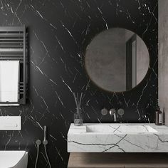 a black and white bathroom with marble counter tops