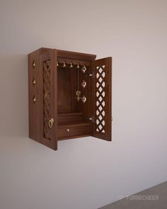 an open wooden cabinet on the wall with jewelry hanging from it's sides and doors