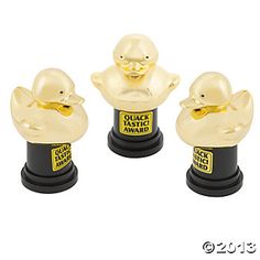 three gold ducky plastic awards on black bases