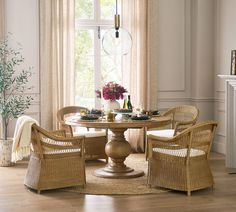 a dining room with wicker chairs and a round table