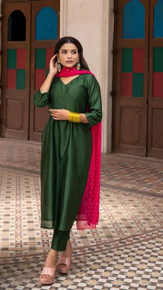 Bring on the festive spirit with our kurta set in chanderi silk. Fully lined kurta and pants. Made in chanderi silk. Dupatta in mul cotton with intricate tikki details. Color of Kurta + Pants : Dark Green. Color of Dupatta : Rani Pink. Model height is 5.3” and is wearing a size S. Wash Care : Dry Clean Only Green Dupatta Combination Suit, Dark Green Suit Women Indian, Cotton Silk Salwar Kameez With Gota Work, Unstitched Slub Silk Kurta For Navratri, Straight Cotton Silk Salwar Kameez With Cutdana, Slub Silk Straight Kurta Salwar Kameez With Dupatta, Straight Salwar Kameez In Cotton Silk With Cutdana, Navratri Straight Kurta In Slub Silk, Bollywood Style Straight Slub Silk Kurta