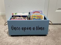 a blue box filled with books sitting on the floor