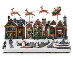 a christmas village with santa's sleigh and reindeers