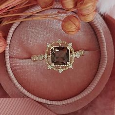 a ring with a brown stone surrounded by flowers