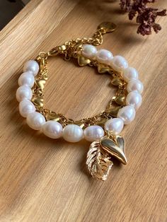 Details: * Gold: St.steel/Brass + 18K Gold plated * Platinum: St.steel/Brass + Rhodium plated * Natural shell beads; pendants are Removable (Transformer lock) * No risk of allergy (nickel-free, lead-free, cadmium-free) * Size:  length adjustable: 16 + 5 cm (basic lock) * The shape and color of the pearls may vary * Delivered with a cleaning cloth and a ready-to-gift jewelry storage pouch * FREE USAVEL GIFT BOX +50e GIFT At checkout, you can send your selected items straight to your friend or lov Feather Bracelet, Bracelet Heart, Gift Bracelet, Gems Bracelet, Freshwater Pearl Bracelet, Bracelet Gemstone, Storage Pouch, Shell Beads, Heart Bracelet