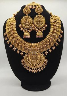 a gold necklace and earring set on display