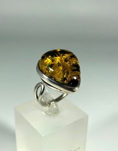 Discover the timeless elegance of our Spectacular Green Amber Ring, expertly crafted for ladies in stunning 925 sterling silver. This exquisite piece features natural Baltic Sea amber, renowned for its unique beauty and healing properties. Perfect for any occasion, this amber ring will add a touch of sophistication to your jewelry collection. Product Details: Material: 925 Sterling Silver Stone: Natural Baltic Sea Amber Color: Spectacular Green Design: Minimalist Style Ring Size: Adjustable Size Amber Open Ring For Anniversary, Silver Cabochon Rings Fine Jewelry, White Gold Rings With Shiny Finish For Gift, Sterling Silver Ring With Shiny Finish, Classic Amber Rings For Formal Occasions, Elegant Amber Cabochon Ring, Formal Amber Ring Jewelry, Amber Rings For Formal Occasions, Fine Jewelry, Timeless Rings With Shiny Finish As Gift