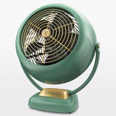 a green fan sitting on top of a metal stand