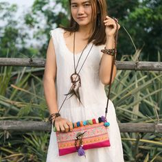 "This beautiful crossbody bag is made with an amazing piece of fabric woven by the HMONG hill tribes of Lanna Country (Northern Thailand). It decorate with multi pom pom. It features a zippered opening area, inside zippered pocket and removable strap. It's a great bag for carrying anything. We buy materials from Hmong market and we design and sew by hand. Some of the bags we modify to improve the product. The Hmong tribes live in the North of Thailand and have origins from the Tibetan area of Ch Embroidered Crossbody Shoulder Bag For Travel, Bohemian Handheld Shoulder Bag With Removable Pouch, Woven Pouch Shoulder Bag For Festivals, Bohemian Embroidered Crossbody Shoulder Bag, Festival Shoulder Bag For Mobile Phone, Festival Crossbody Mobile Phone Bag, Bohemian Everyday Use Pouch, Bohemian Woven Clutch Shoulder Bag, Bohemian Embroidered Clutch Bag