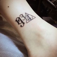 a tattoo on the foot of a person with an upside down triangle and letter b