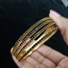 "* Handcrafted Gold Plated 4 Bangle Set. Sold as a set. * Bangles with high quality black stones. * High Quality 22K Gold Plated. Bangles Sizes : 2.4 inches= ( 2.25\" diameter of the inner circle) ; 2.6 inches = ( 2.40\" diameter of the inner circle); 2.8inches = (2.54\" diameter of the inner circle) The gorgeous gold-plated bangles set best exemplifies the careful craftsmanship done on it -- specially picked for you by Nemali Jewelry. It has a special tone of elegance attached to it. The intric Traditional Black Bracelets For Party, Traditional Black Party Bracelets, Traditional Black Bracelets For Weddings, Traditional Black Bracelet For Wedding, Traditional Black Wedding Bracelets, Black Bangle Bracelets For Festive Occasions, Festive Black Bangle Bracelets, Traditional Black Bangle Jewelry, Festive Black Bangle Bracelet