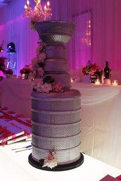 a tall silver cake sitting on top of a table