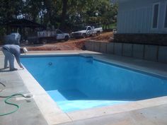 a man is cleaning the pool with a hose