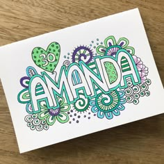 a card with the word amanda written in colorful doodled letters on top of it