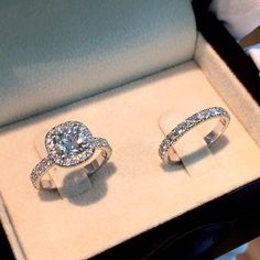 two engagement rings sitting in a box on display