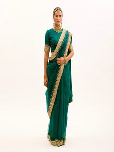 Featuring an Emerald Green Saree in silk organza base with hand embroidered gota and marodi Border. It is paired with matching Modal Satin Petticoat and Silk Stitched Blouse having having makes and gota embroidery. Fabric: Pure Silk Organza, Habutai Silk, Pure Modal Satin Lining Fabric - Cotton Color: Green Emboridery & Embellishments: Gota, Mukeish and marodi work Blouse Neck: Crew / Jewel neck Fit: Fitted at bust and waist Note: The product will be delivered within 3-4 weeks of the order place Tissue Silk Traditional Wear With Sheer Dupatta For Reception, Reception Traditional Wear With Sheer Dupatta In Tissue Silk, Chanderi Saree For Reception, Chanderi Anarkali Saree Set For Reception, Chanderi Pre-draped Saree With Dori Work For Reception, Pre-draped Dola Silk Saree With Sheer Dupatta For Reception, Organza Blouse Piece For Diwali Reception, Reception Dola Silk Pre-draped Saree With Sheer Dupatta, Organza Pre-draped Saree For Reception Diwali