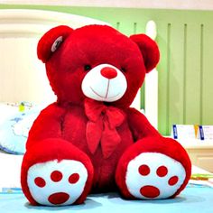 a red teddy bear sitting on top of a bed