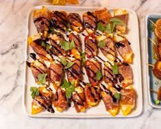 two trays filled with food on top of a marble countertop next to each other