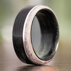 a black and white wedding ring with antler wood inlays on the inside