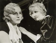 black and white photograph of two women in front of a mirror looking at each other