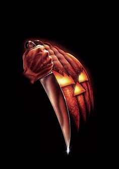 a hand holding a knife in the shape of a pumpkin