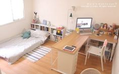 a small bedroom with a bed, desk and computer on top of the desk in front of it